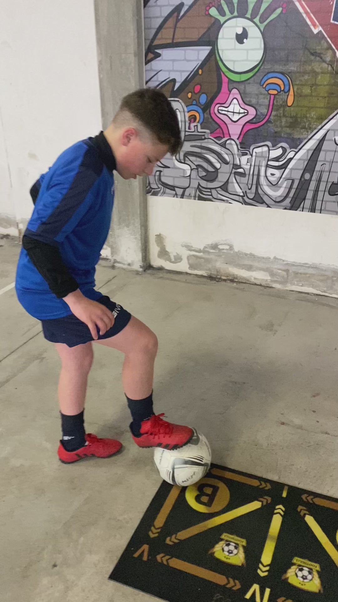 Outdoor training session on a soccer mat, focusing on ball control and agility drills.