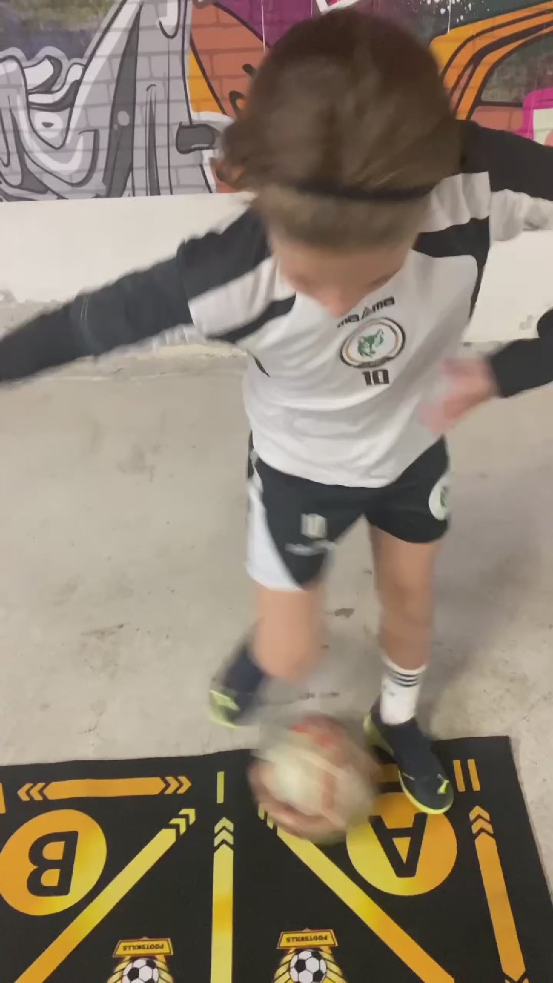 Child performing soccer exercises on a directional training mat, highlighting ball control.