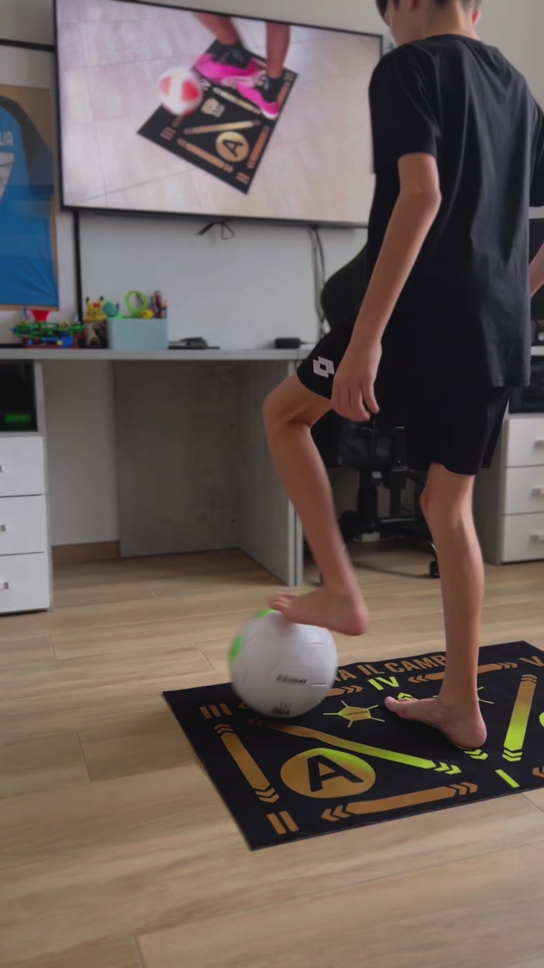 Young athlete performing footwork drills on a soccer mat with a ball indoors, with a focus on precision.